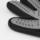 Close-up of a black grooming glove with rubber bristles for pet hair removal.
