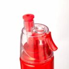 Close-up of a red and transparent liquid soap dispenser against a white background.