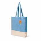 Blue and beige tote bag with long handles and a brown tag attached near the top.