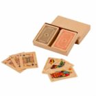 Two decks of vintage playing cards in a box, with several cards spread out in front.