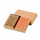 Two decks of playing cards, one brown and one red, in an open cardboard box.