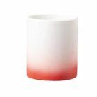 White ceramic cup with a red gradient at the base, on a plain white background.