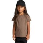 Young child in a brown t-shirt and black cap stands against a plain white background.