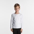 Young boy in a white long-sleeve shirt and black pants standing against a white background.