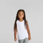 Child with long hair wearing a white tank top and gray pants against a plain background.