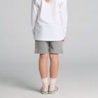 A child in a white shirt, gray shorts, and sneakers standing facing away.