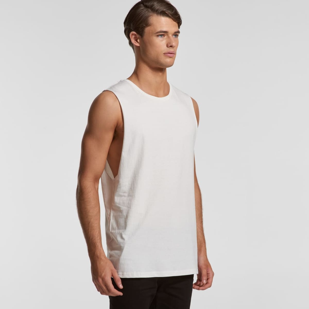 Young man wearing a sleeveless white muscle shirt and black pants, facing slightly right.