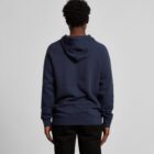 A person wearing a navy hoodie and black pants, facing away from the camera.