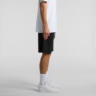 Person in white shirt, black shorts, white socks, and white sneakers standing sideways.