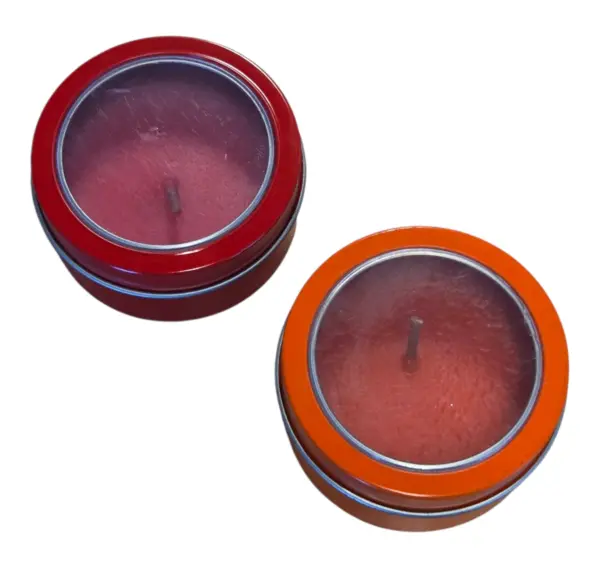 Two round candles in red and orange tins