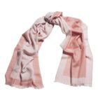 A soft pink and white scarf with fringed edges, loosely arranged on a white background.