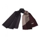 Color-block scarf in black, brown, and beige tones with fringed edges, laid flat.