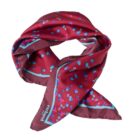 Red silk scarf with blue and purple floral pattern and light blue-bordered edges.