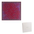 A red silk scarf with blue floral pattern, shown with a white Cacharel box.