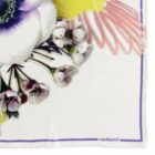 Close-up of a floral patterned scarf with cacharel text in the bottom right corner.