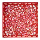 Red scarf with swirling pink, white, and beige heart and floral patterns, Cacharel logo at bottom.