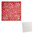 Red and pink floral patterned scarf with a white Cacharel box beside it.