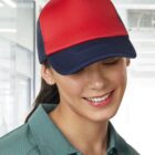 Person in a red and navy cap smiling and looking down, wearing a green collared shirt.