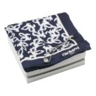 Navy and white patterned Cacharel scarf with a silver bracelet on a white box.