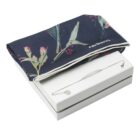 Navy floral scarf and delicate silver bracelet on a white box.