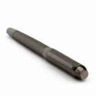 A textured black pen lies diagonally on a white surface.