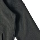 Close-up of a dark grey long-sleeve garment on a white background.