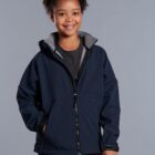 Smiling child wearing a navy blue jacket with hands in pockets against a gray background.