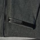 Close-up of a gray jacket zipper and pocket with a black plastic loop detail.