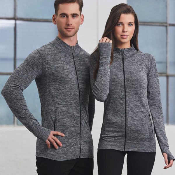 Man and woman in matching gray zip-up jackets standing indoors, posing for a photo.