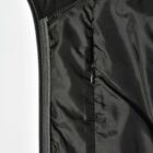Close-up of a black jacket’s inner lining with a visible zipper pocket.