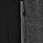 Close-up of a gray zipper between black fabric and gray textured fabric.