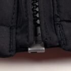 Close-up of a black zipper on a dark fabric garment.