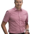 Man wearing a red and white checkered short-sleeve shirt, standing and smiling.