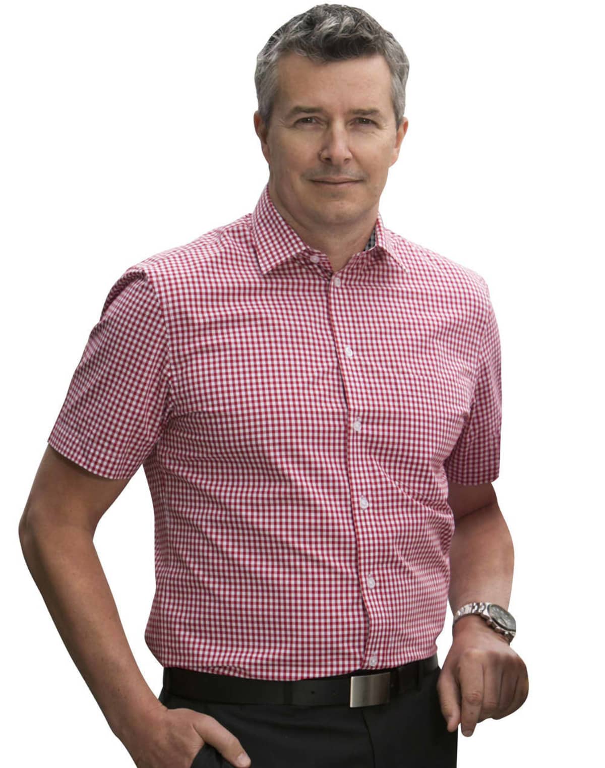 Man wearing a red and white checkered short-sleeve shirt, standing and smiling.