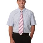 Man wearing a short-sleeve dress shirt and striped tie, smiling with one hand in pocket.