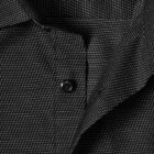 Close-up of a black shirt with a small white dot pattern and a visible black button.