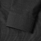 A close-up of a dark shirt cuff with a subtle white dotted pattern.