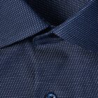 Close-up of a navy blue dress shirt with a small white dotted pattern and a blue button.