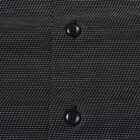 Close-up of a black shirt with white dotted pattern and two black buttons.