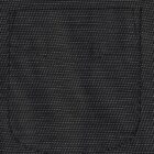 A close-up of a dark denim fabric with a stitched pocket outline.