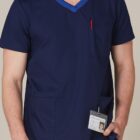 Person in navy blue scrubs with an ID badge and pen in the chest pocket.