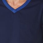 Person wearing a dark blue scrub top with a blue V-neck collar and chest pocket.
