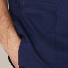 A person’s hand is in the pocket of navy blue pants.