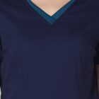 Close-up of a person wearing a navy blue V-neck scrub top with a teal undershirt.