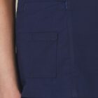 Close-up of a navy blue pocket on a garment, with a persons hand resting by their side.