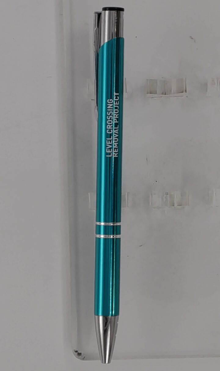 A blue and silver pen labeled LEVEL CROSSING REMOVAL PROJECT on a white background.