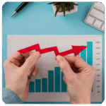 Hands hold a red arrow over a bar graph, symbolizing business growth and achieving business goals.