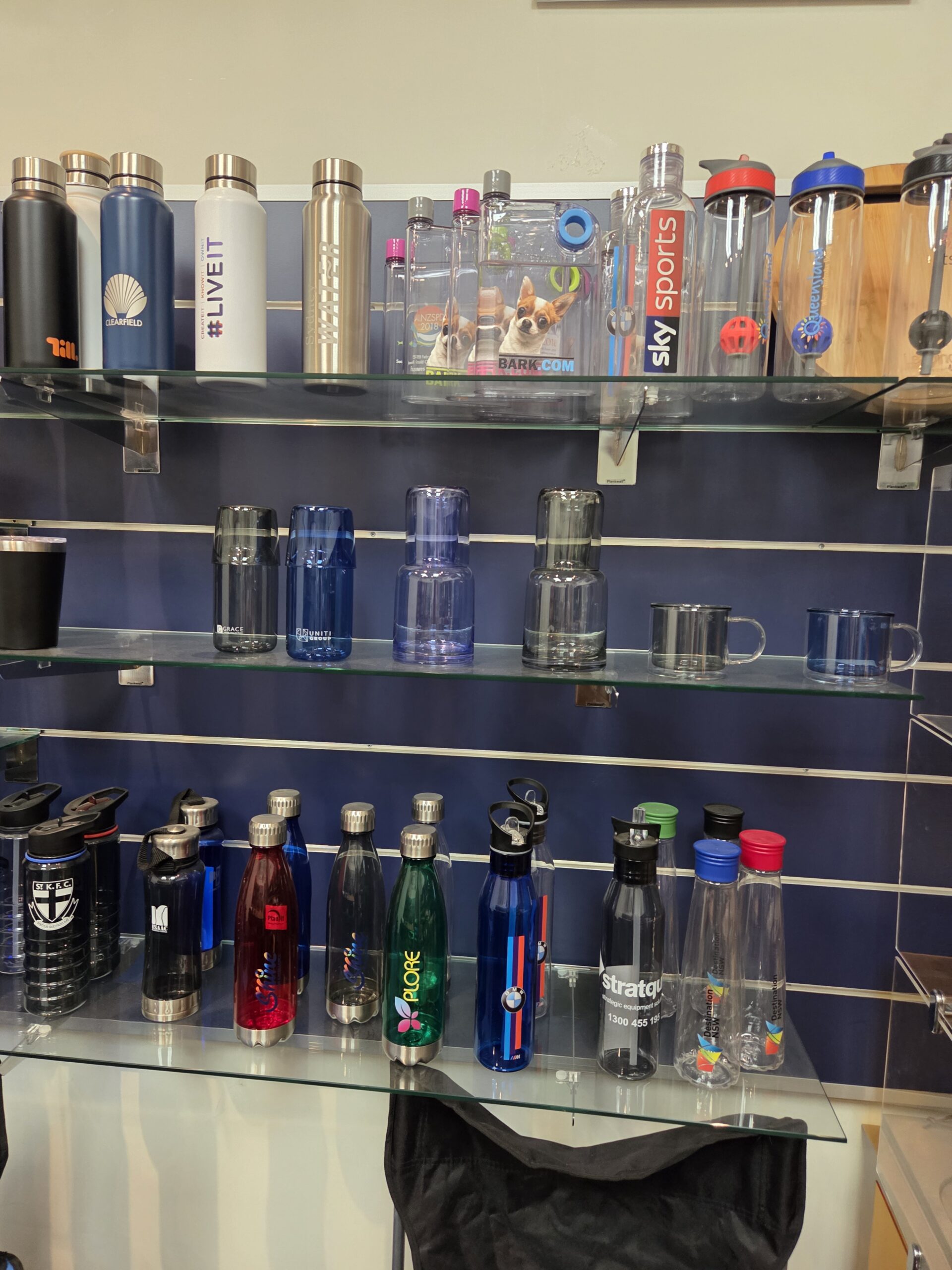 Glass shelves showcasing water bottles—a smart marketing strategy for attracting shoppers.
