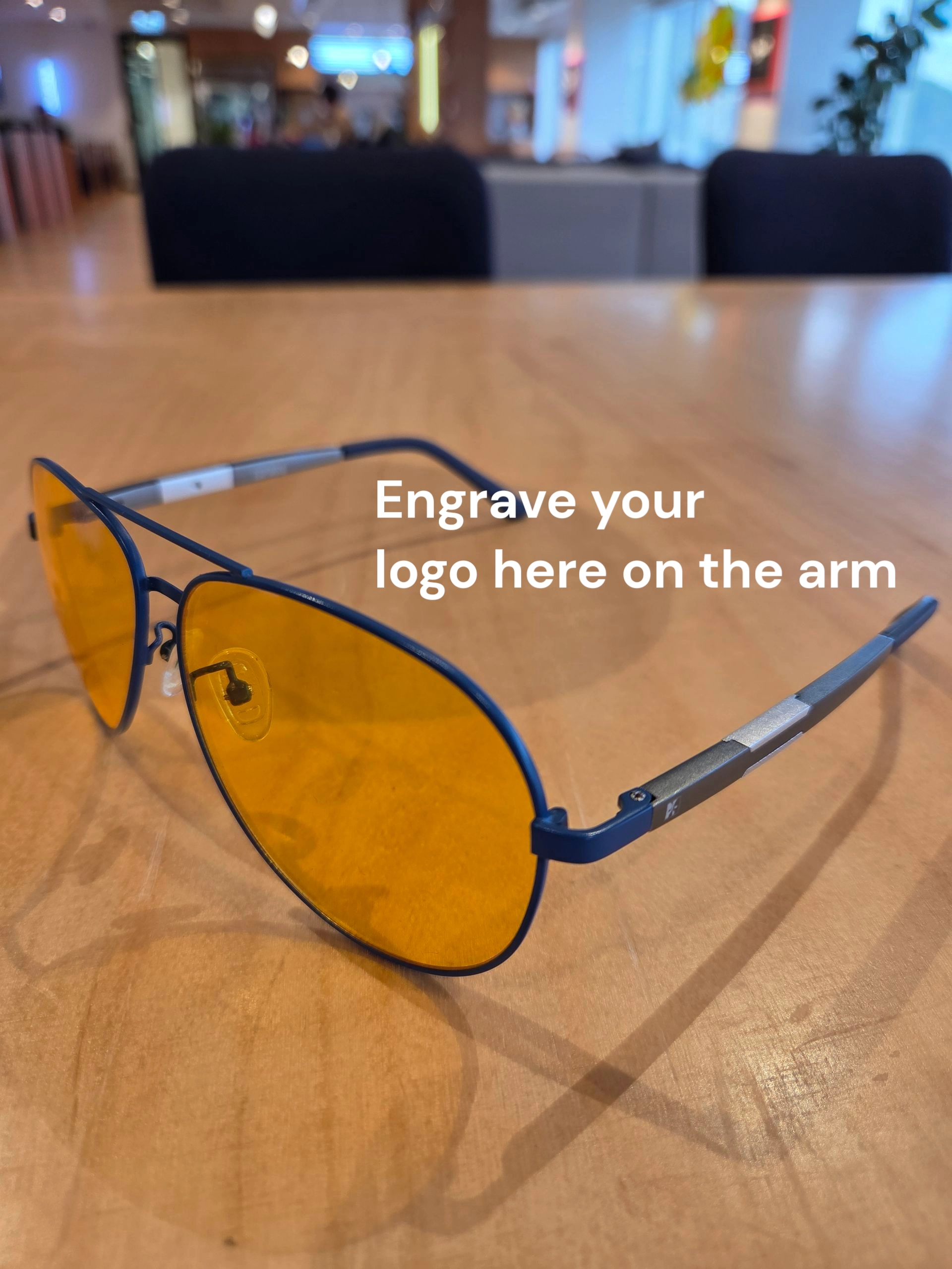 Blue sunglasses with yellow lenses—unique merch ideas; engrave your logo on the arm.