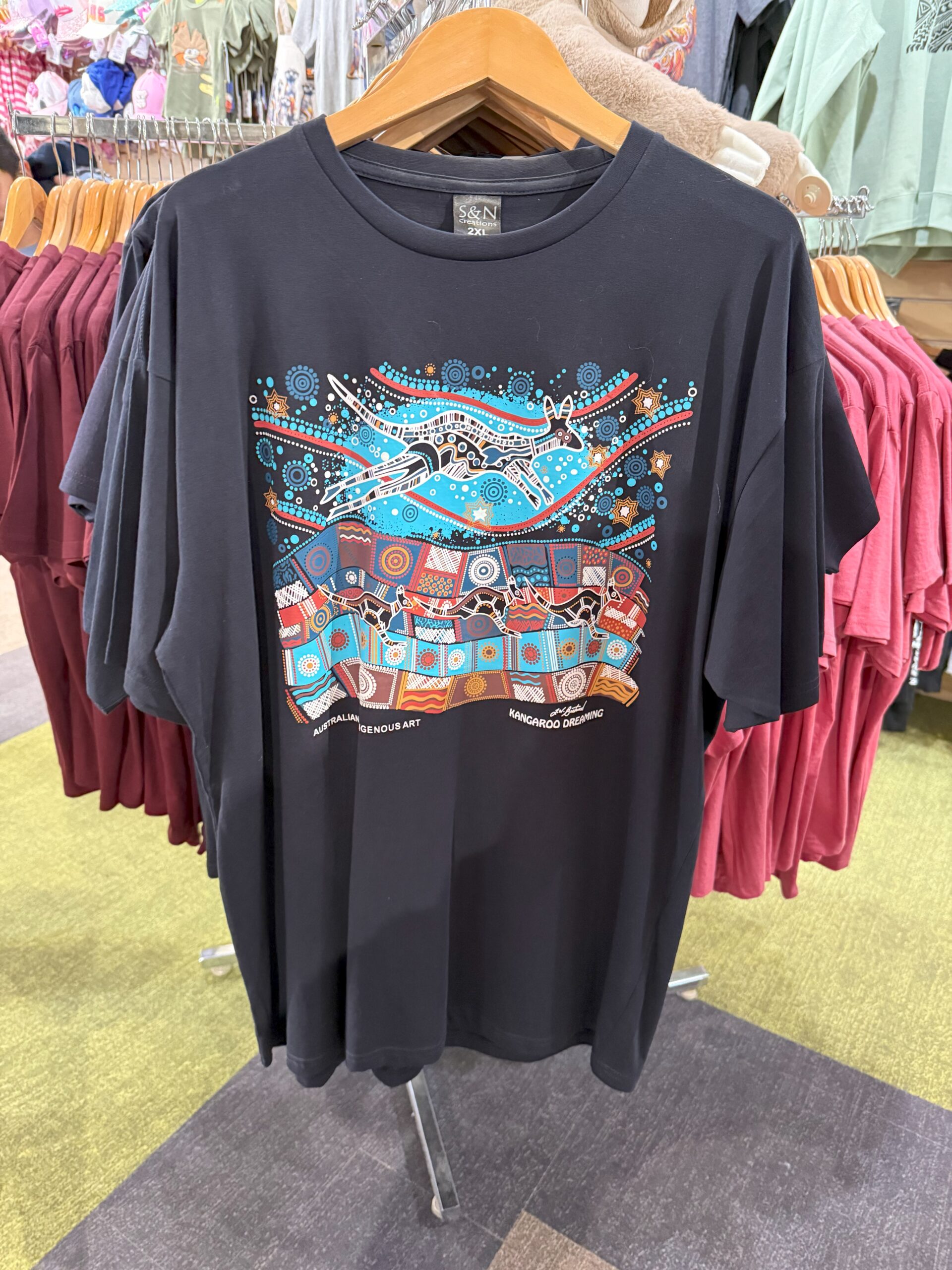 Black T-shirt with colorful Aboriginal-style kangaroo art—perfect zoo merchandise for experience.